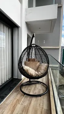 a wicker chair sitting on a balcony at La Perle - Luxe & élégance Face à la gare Agdal in Rabat