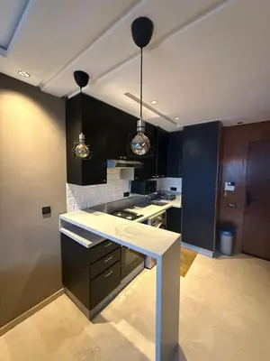 a kitchen with black cabinets and a white counter top at Calme et Comfort ,cozy, centre de Casablanca in Casablanca