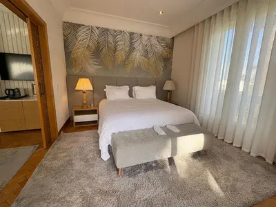 a bedroom with a white bed and a large window at Palais Elya in Rabat
