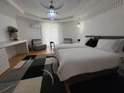 a bedroom with two beds and a chandelier at Palais Elya in Rabat