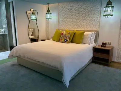 a bedroom with a large white bed with green pillows at Palais Elya in Rabat