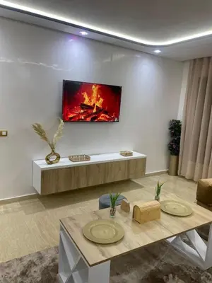 a living room with a fire painting on the wall at Studio Chic & Neuf au Cœur de Bourgogne in Casablanca-Port