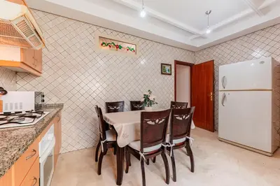 a kitchen with a table and chairs and a refrigerator at Confort Urbain - Plein centre & Spacieux in Casablanca