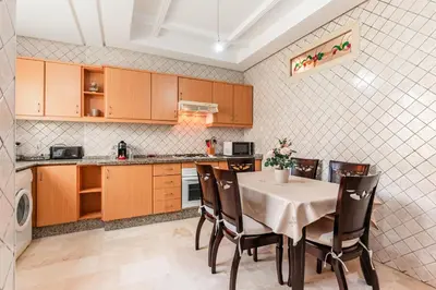a kitchen with a table and chairs in a kitchen at Confort Urbain - Plein centre & Spacieux in Casablanca