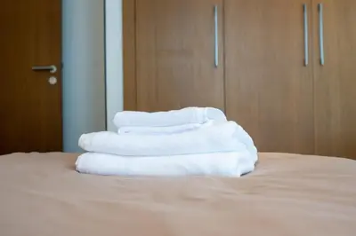 a stack of white towels sitting on top of a bed at Modern CFC Flat with Terrace Gym & City Views in Casablanca