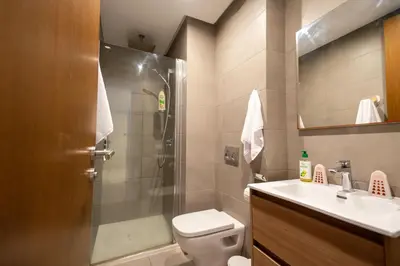 a bathroom with a shower and a toilet and a sink at Modern CFC Flat with Terrace Gym & City Views in Casablanca