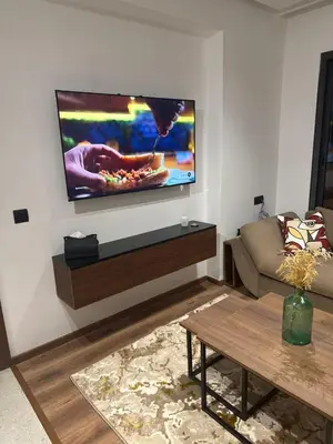a living room with a flat screen tv on a wall at Studio Premium Maarif in Maarif