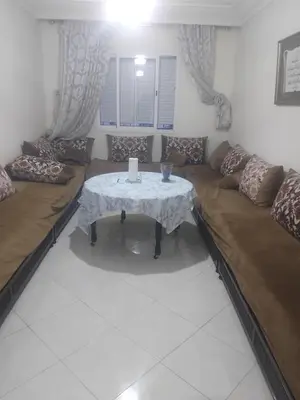 a living room with a table and a couch at اقامة جنان تمارة تمارة in Temara