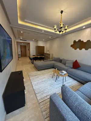 a living room with blue couches and a table at Appartement Haut Standing in Casablanca