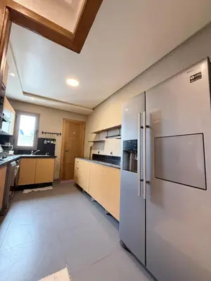 a large kitchen with a large stainless steel refrigerator at Appartement Haut Standing in Casablanca