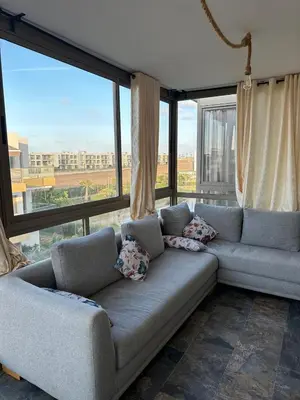 a couch in a living room with a large window at Residence blue beach Sidi Rahal in Sidi Rahal