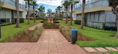 a sidewalk in front of a building with a parking meter at Residence blue beach Sidi Rahal in Sidi Rahal