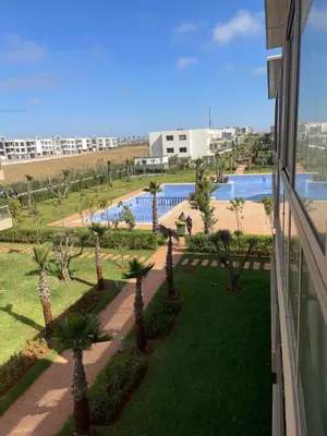 a view from the balcony of a resort with palm trees at Residence blue beach Sidi Rahal in Sidi Rahal