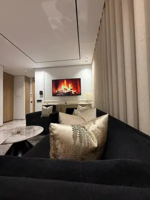 a living room with a black couch and a tv at Jolie studio plein centre Casablanca in Casablanca