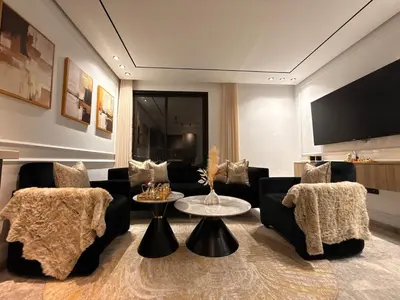 a living room with couches and a table and a tv at Jolie studio plein centre Casablanca in Casablanca