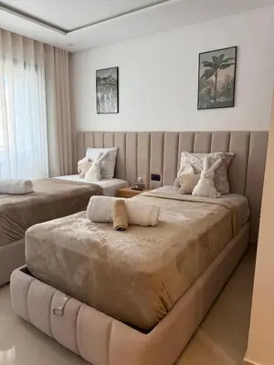 two beds in a hotel room with two beds at appartement de Lux le clos in Bouznika