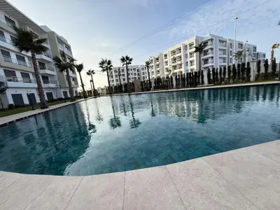 a large swimming pool in front of some buildings at appartement de Lux le clos in Bouznika
