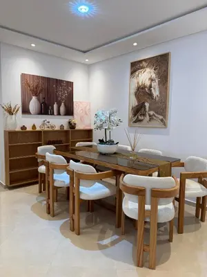 a dining room with a wooden table and chairs at appartement de Lux le clos in Bouznika