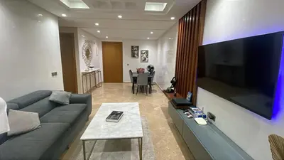 a living room with a couch and a large flat screen tv at Appartement magnifique et moderne in Temara