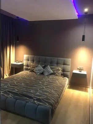 a large bed in a bedroom with purple lights at Appartement magnifique et moderne in Temara