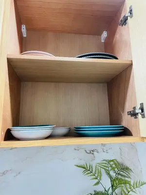 a wooden shelf with bowls and plates on it at Private Room,Piscine & Parking en cohabitation avec le hôte seulement à 6 min Airport MohamedV in Nouaceur