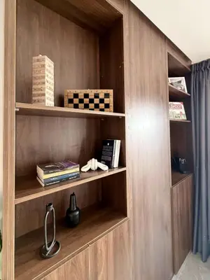 a book shelf in a room with books at Luxury 1BR CFC with Pool, Balcony & City View in Casablanca