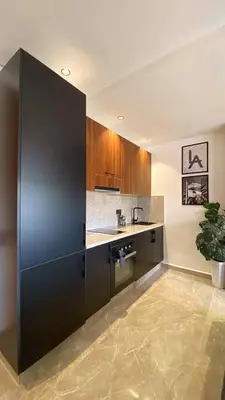 a kitchen with a large black refrigerator in a room at Luxury 1BR CFC with Pool, Balcony & City View in Casablanca
