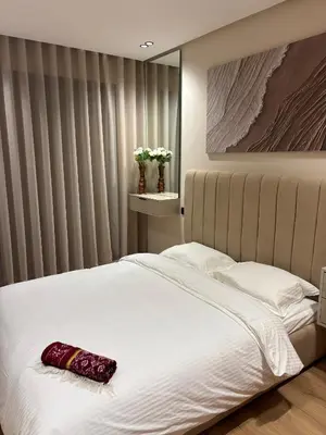 a bedroom with a white bed with a red pillow on it at Bridge Collection - Mirage in Casablanca