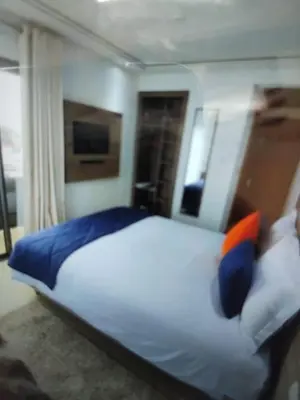 a bedroom with a large white bed with blue and orange pillows at Belle chambre pour 2 sidi maarouf HOTEL in Casablanca