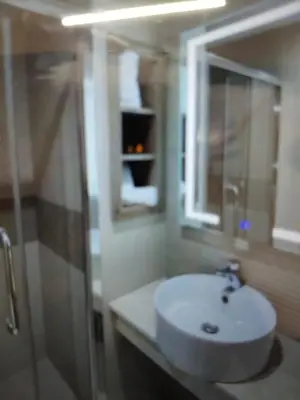 a bathroom with a sink and a mirror and a shower at Belle chambre pour 2 sidi maarouf HOTEL in Casablanca