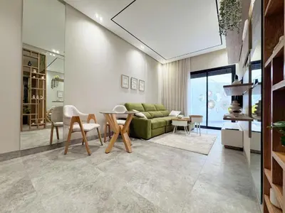 a living room with a green couch and a table at anfa park residence beau living park in Casablanca
