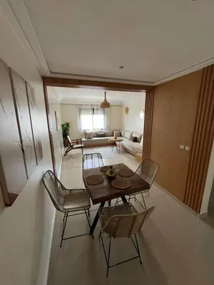 a room with a table and chairs and a living room at Charmant appartement in Casablanca center city in Casablanca