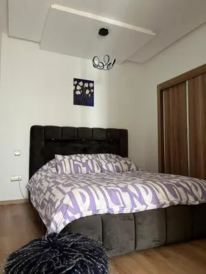 a bedroom with a bed with a purple comforter at Cosy Appart au Parc Mohammédia in Mohammedia