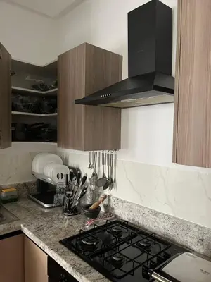 a kitchen with a stove and a counter top at Cosy Appart au Parc Mohammédia in Mohammedia