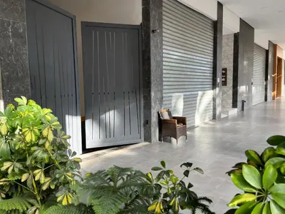 a lobby with a door with a chair and some plants at Cosy Appart au Parc Mohammédia in Mohammedia