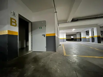 an empty parking garage with a white door and yellow stripes at Cosy Appart au Parc Mohammédia in Mohammedia