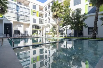 an empty swimming pool in front of a building at Piscine Chauffée Salle de Sport Balcon Panoramique in Mohammedia