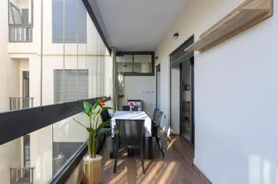 a dining room with a table and chairs on a balcony at Piscine Chauffée Salle de Sport Balcon Panoramique in Mohammedia