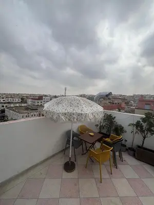 a patio with a table and chairs and an umbrella at studio elevator, renovated air-conditioned breakfast in Casablanca