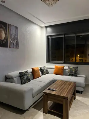 a living room with a couch and a coffee table at Cozy appartement avec piscine in Bouznika