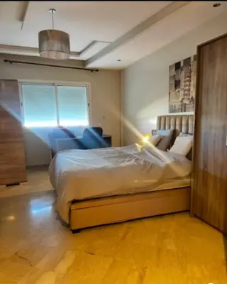 a bedroom with a bed and a chair in it at Family appartment in Casablanca