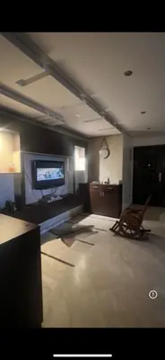 a living room with a tv and a chair at Family appartment in Casablanca
