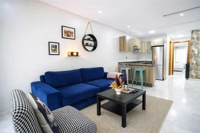 a living room with a blue couch and a table at Studio Paisible aux Hopitaux Wifi & Parking in Casablanca