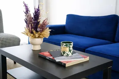 a coffee table with a blue couch and a vase at Studio Paisible aux Hopitaux Wifi & Parking in Casablanca