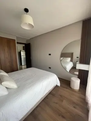 a bedroom with a large white bed and a mirror at Cozy studio for rent Casablanca in Casablanca