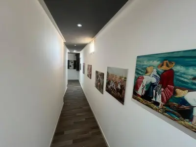 a hallway with paintings on the walls of a museum at Cozy Rabat Studio near Tram & City Center in Rabat