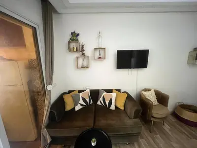 a living room with a brown couch and a tv at Cozy Rabat Studio near Tram & City Center in Rabat