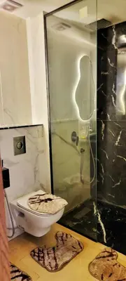 a bathroom with a toilet and a glass shower at Les-iris-Appartement-moderne-chambre-salon-au-cœur-de-Casablanca in Casablanca