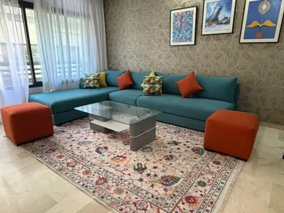 a living room with a blue couch and orange chairs at Urban Square in Casablanca
