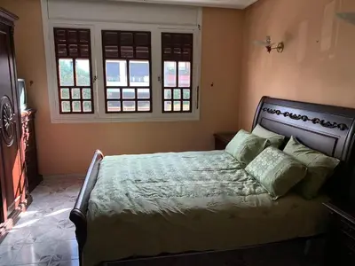 a bedroom with a bed and two windows at Grand Andalusian Villa Private Garage and Garden in Casablanca